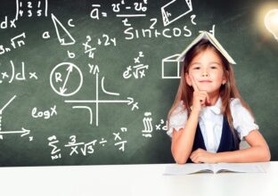 Young cute girl at chalkboard with light bulb over head Back to school! Concept of education, reading and learning.